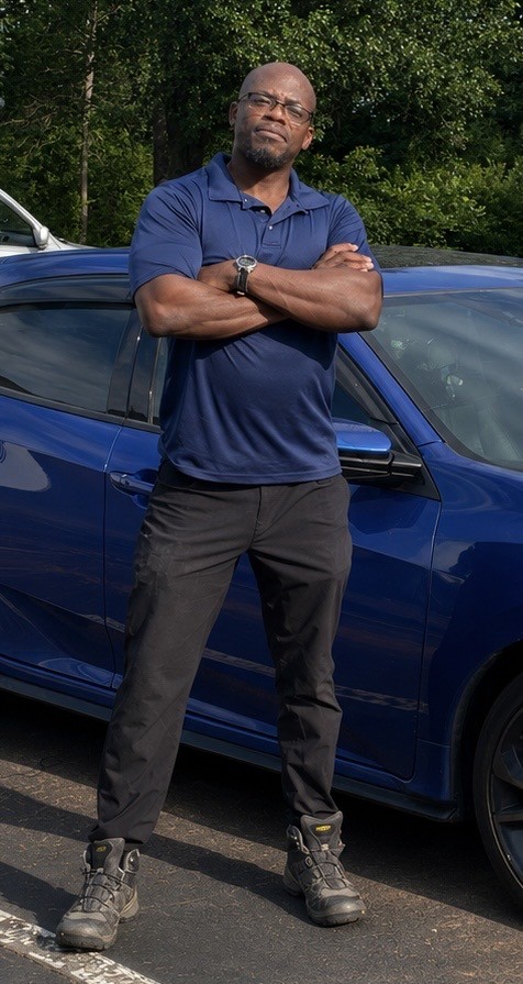 Owner of Diamond Services LLC standing beside a freshly detailed blue vehicle